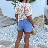 Blusa com mangas bufantes e bainha em formato bubble, estampa abstrata em tons de pedra e creme