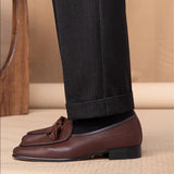 Loafers de couro belga com textura de pedra e detalhe de pompom